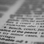 Selective focus on the word 'justice' in a dictionary, conveying law and fairness concepts.