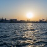 Beautiful sunset view over the harbor of Novorossiysk, showcasing the vibrant sea and skyline.