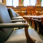 Elegant courtroom seating with leather chairs and wooden desks, exuding a sense of authority.