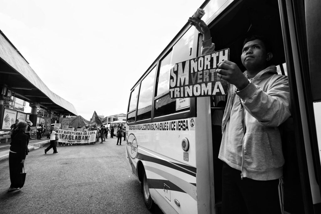 A street protest with demonstrators and a bus in urban surroundings.