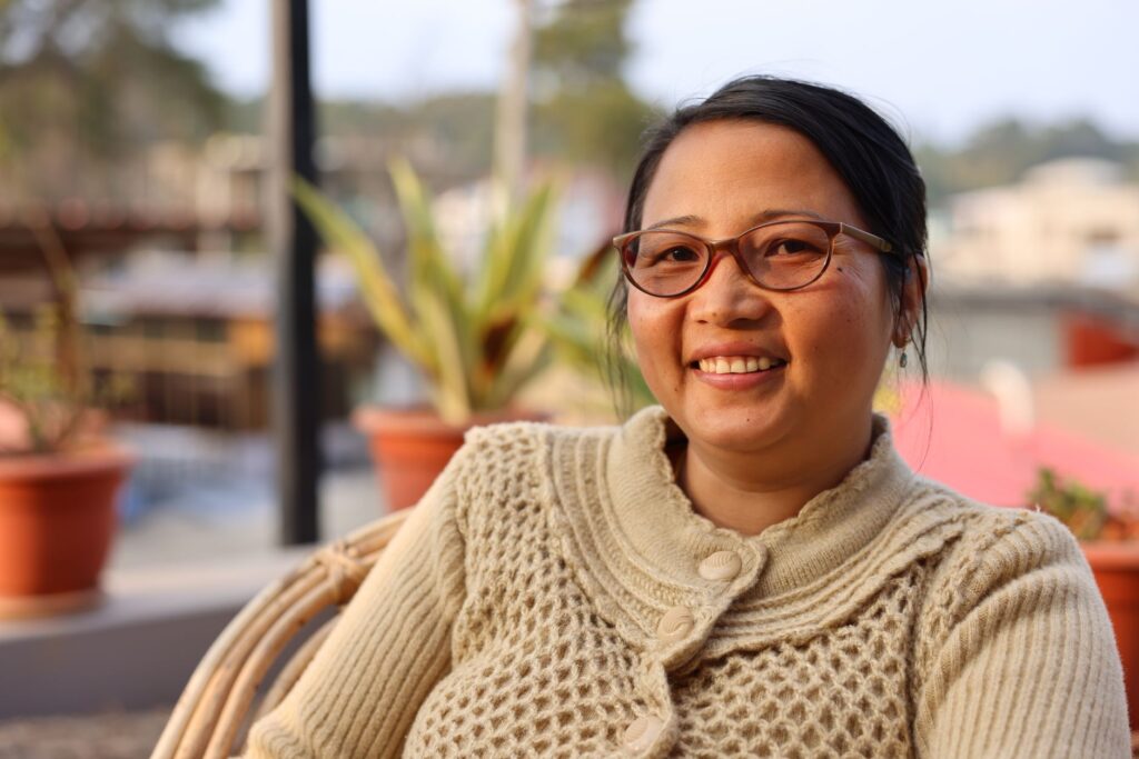Happy woman with eyeglasses and sweater enjoying the outdoors in Manipur, India.