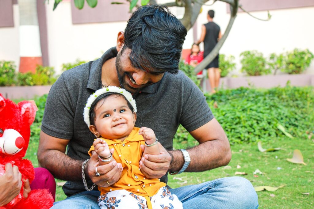 A loving father and his baby daughter enjoy a sunny day together outdoors.