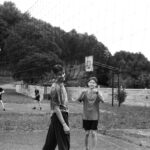 Boys playing volleyball outdoors in Lviv, Ukraine. Black and white capture shows physical activity.