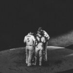 Black and white image of a baseball team huddling on a field under spotlight in Los Angeles, CA.