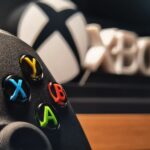 Detailed view of Xbox gaming controller with vibrant buttons displayed indoors.