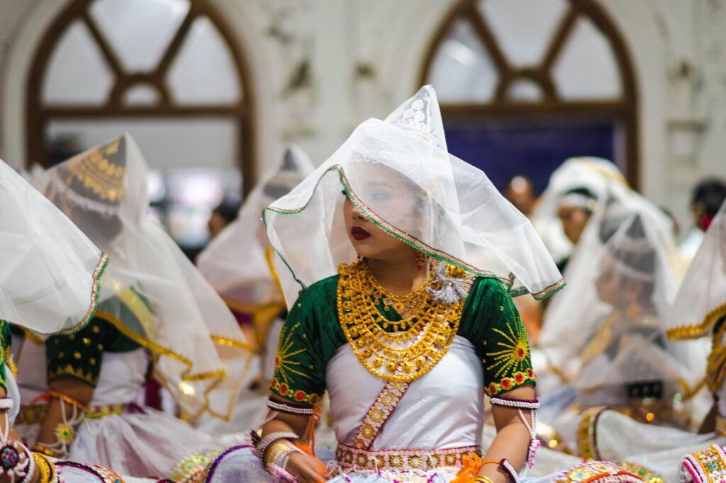 Colorful traditional Meitei dance in a temple in Imphal, Manipur, India, showcasing rich cultural attire.