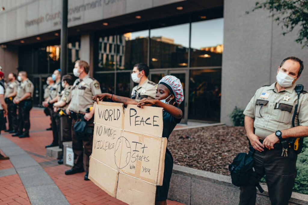 A peaceful protester holds a sign advocating world peace outside Hennepin County Government Center.