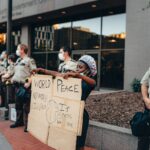 A peaceful protester holds a sign advocating world peace outside Hennepin County Government Center.