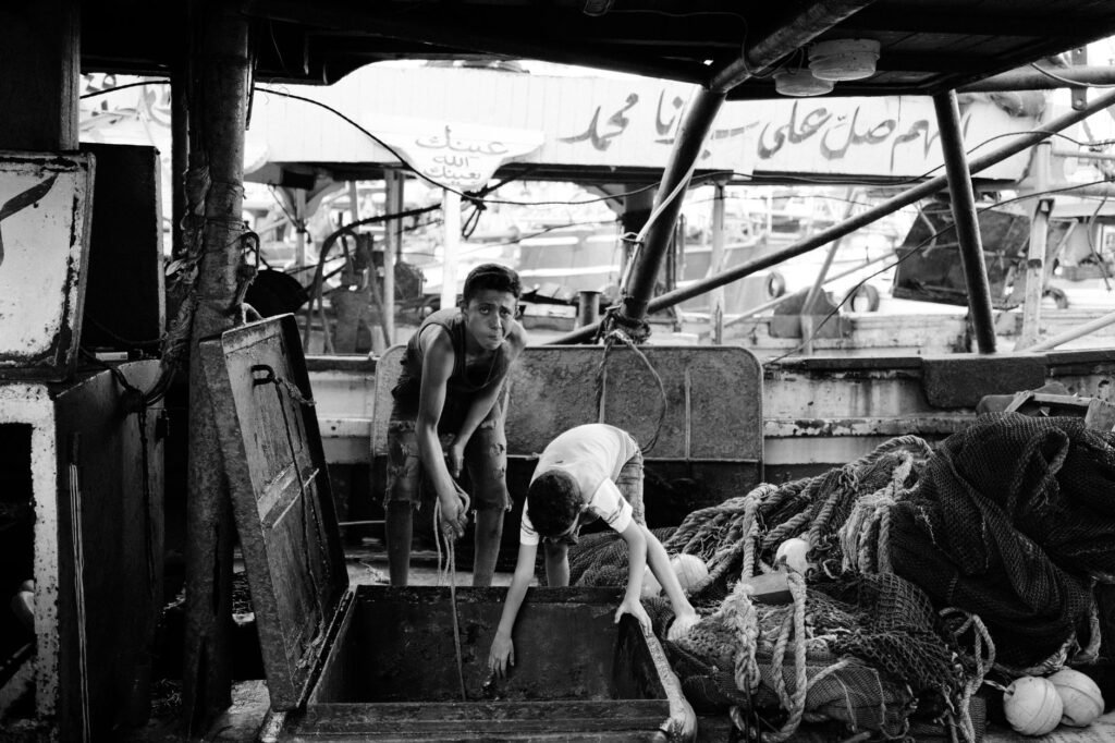 Black and white capture of workers at a Damietta fish market, capturing everyday life.