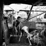Black and white capture of workers at a Damietta fish market, capturing everyday life.