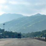 A serene view of a highway with foggy hills in the background, captured in Navi Mumbai, India.