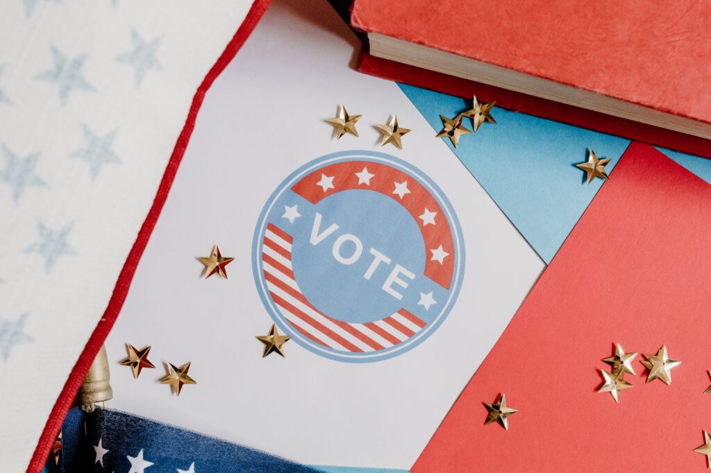 Flat lay of voting symbol with red, white, and blue colors and gold stars, symbolizing American democracy.