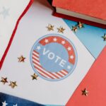 Flat lay of voting symbol with red, white, and blue colors and gold stars, symbolizing American democracy.