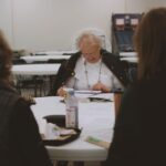 Older women engaging in a Bible study community group session indoors.