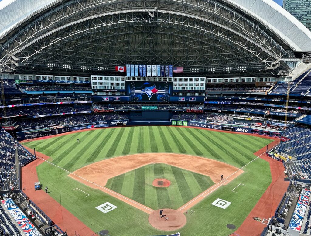 Aerial view of the Rogers Centre stadium during a baseball game in Toronto, displaying its retractable roof.