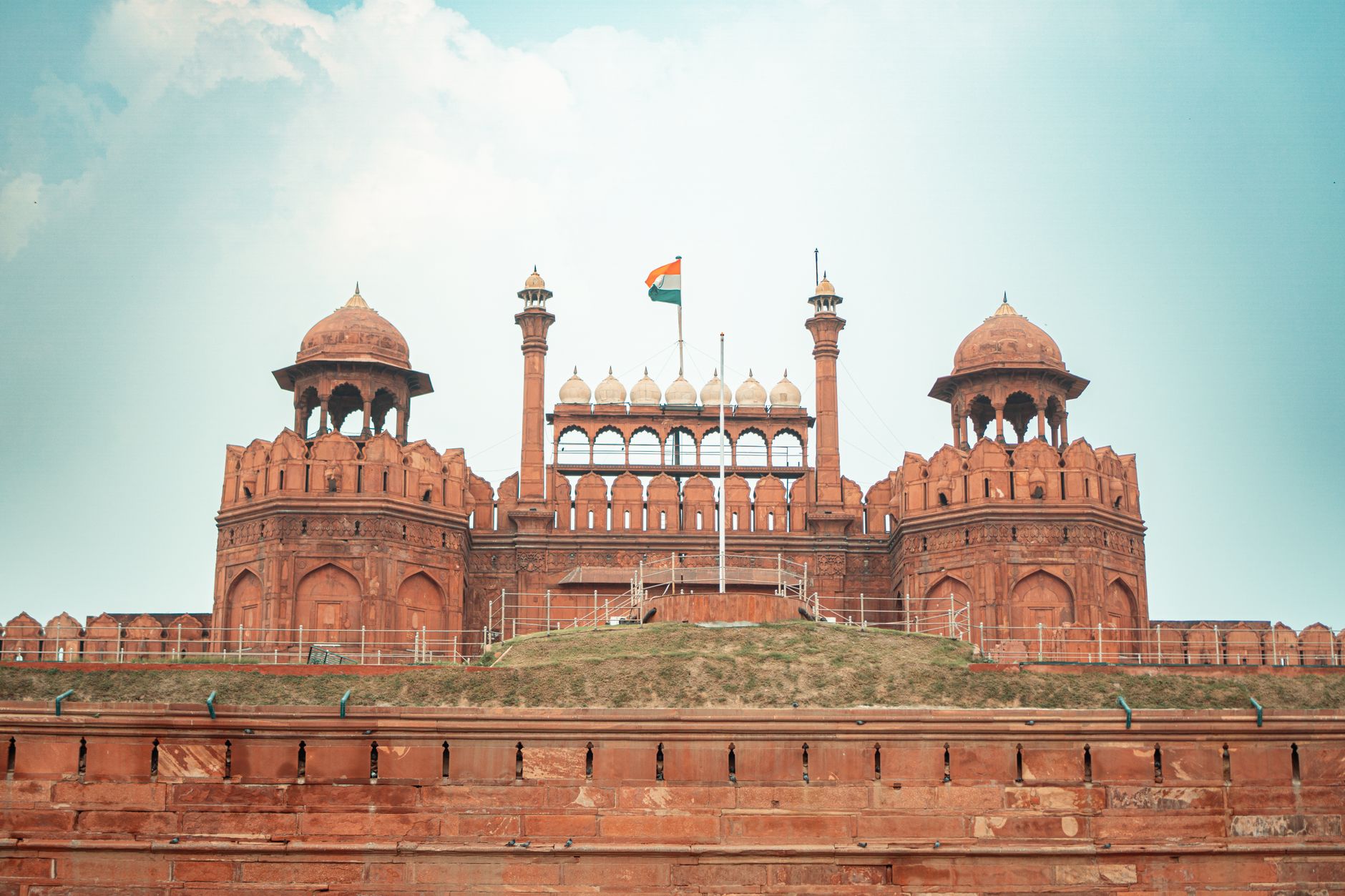 Front view of the historic Red Fort in New Delhi, featuring its iconic architecture and Indian flag.