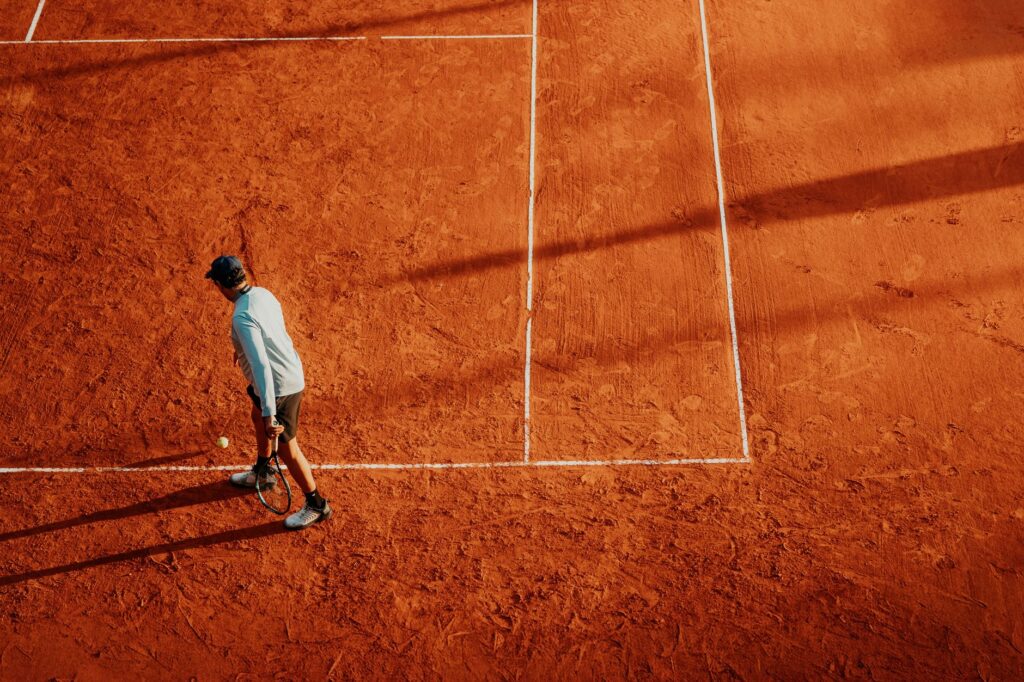 Tennis player practices on a sunny clay court in Buenos Aires, Argentina.