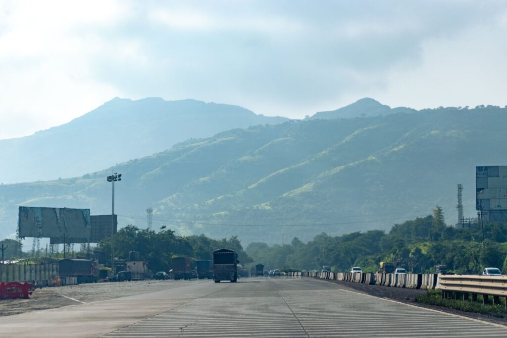 A serene view of a highway with foggy hills in the background, captured in Navi Mumbai, India.