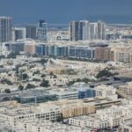 Expansive aerial shot capturing Dubai's modern cityscape with diverse architecture and bustling urban life.
