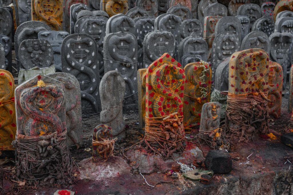 Ancient Naga stones with vibrant markings in a Kanchipuram temple, Tamil Nadu, India.