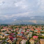 Stunning aerial view of colorful Srinagar city with Himalayan backdrop under cloudy skies.