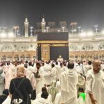 A large crowd of pilgrims at the Kaaba in Mecca during a religious gathering at night.