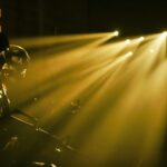 Silhouetted soldiers with dramatic beams of light in a military setting.