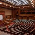 Captivating wide-angle view of a classic legislative assembly hall with ornate wood design.