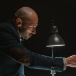 A detective presenting evidence during an intense interrogation scene.