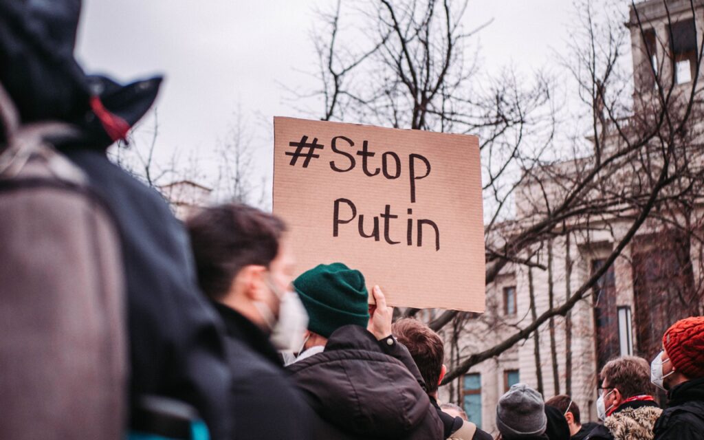People in Berlin protest against Putin with anti-war signs, showing unity for peace.