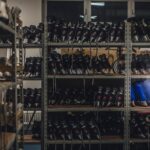 Neatly organized skate boots on shelves in an indoor shop setting, ready for sale.