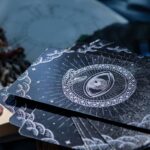 A captivating close-up of tarot cards beside an open book, embodying the mystery of fortune telling.
