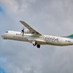 A vibrant ATR 72-500 airplane soaring through the sky, showcasing aviation dynamics and travel concepts.