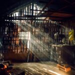 Sunlight streaming through a rustic bamboo hut creating a warm, serene atmosphere.