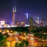 A mesmerizing cityscape at night featuring illuminated skyscrapers and busy street light trails.