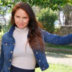 Casual portrait of a woman enjoying a sunny day in a garden setting.