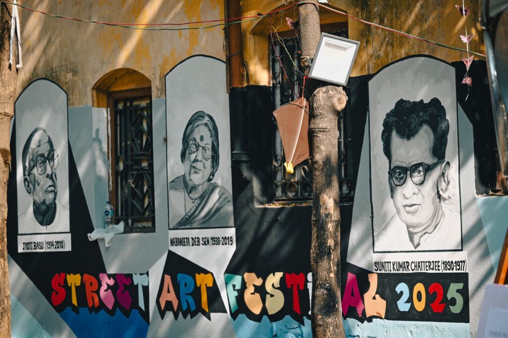 Vibrant street art mural depicting famous figures at a festival in Kolkata, India.