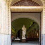Explore the beauty of this church entrance with a detailed religious statue inside.