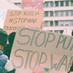 Protest signs at a rally expressing anti-war and anti-Putin sentiments.