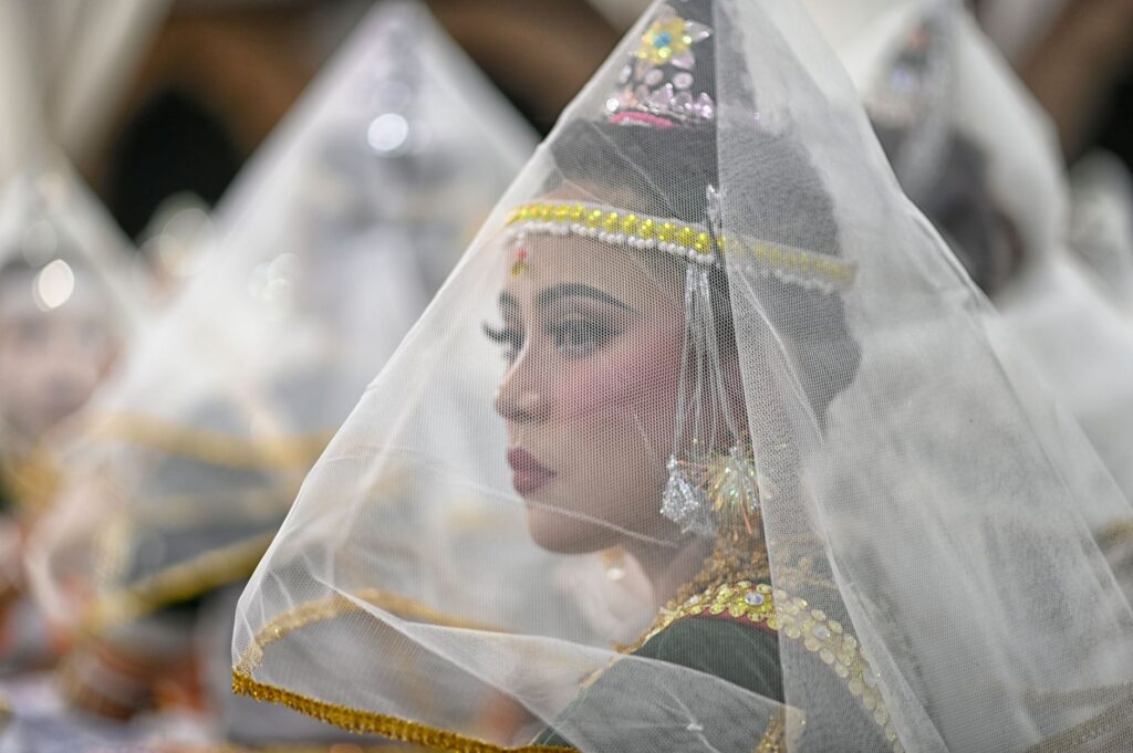 A Manipuri dancer adorned in traditional attire during a cultural performance in Imphal, India.