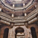 A stunning view of the intricately designed ancient stepwell architecture with stone columns.