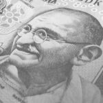 Detailed monochrome depiction of an Indian rupee banknote with Gandhi's portrait, symbolizing finance and economy.