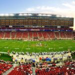 A stunning panoramic shot of Levi's Stadium in Santa Clara during a packed football game at sunset.