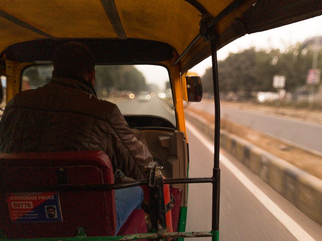 Inside view of a moving autorickshaw on Gurugram road, capturing urban dynamics.