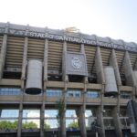 Impressive view of the iconic Santiago Bernabéu Stadium in Madrid, Spain, captured during a bright summer day.