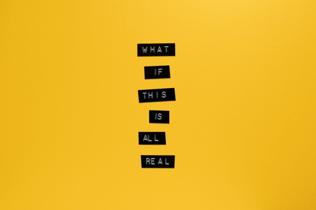 Inspirational text 'What if this is all real' on yellow surface.