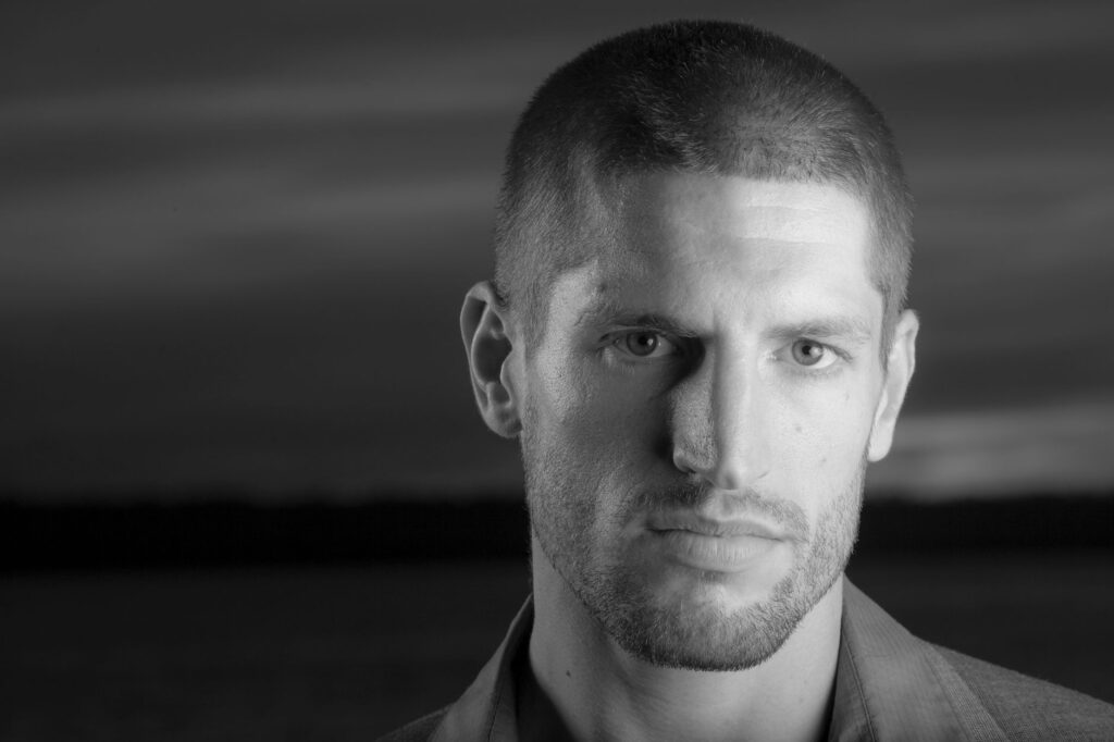 Close-up black and white portrait of a man, emphasizing strong features and mood.