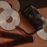 Retro collection featuring vintage camera, film negatives, and CDs for nostalgic photography enthusiasts.
