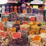 Vibrant display of candies and nuts in a Mexican market with colorful pricing tags.