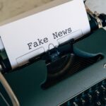 Close-up of a vintage typewriter displaying the words 'Fake News' on paper.